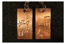 刀匠が銅板のキーホルダーに文字をお入れします。